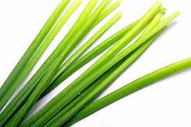 A close up of some green onions on a white surface