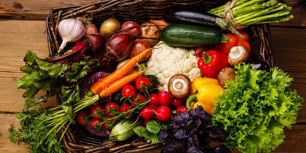 A basket full of fresh vegetables and fruits.