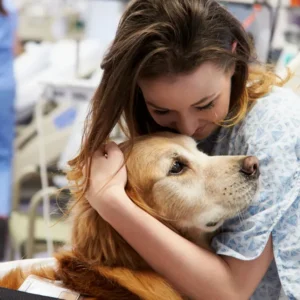 A woman holding onto her dog in the hospital