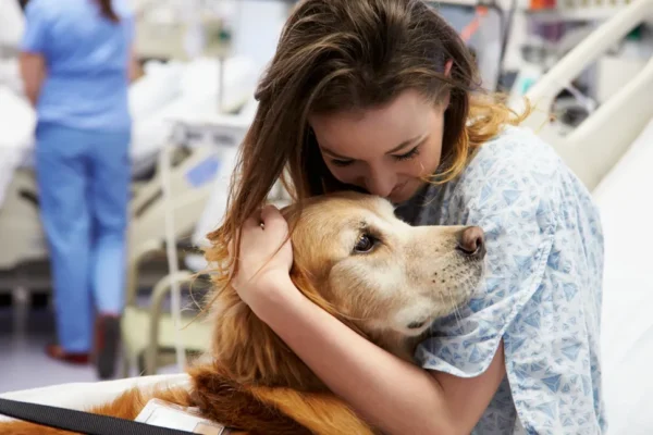 A woman holding onto her dog in the hospital