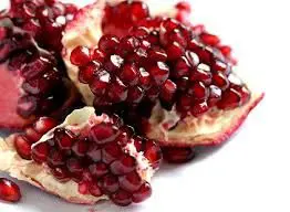 A close up of some pomegranate pieces on a plate